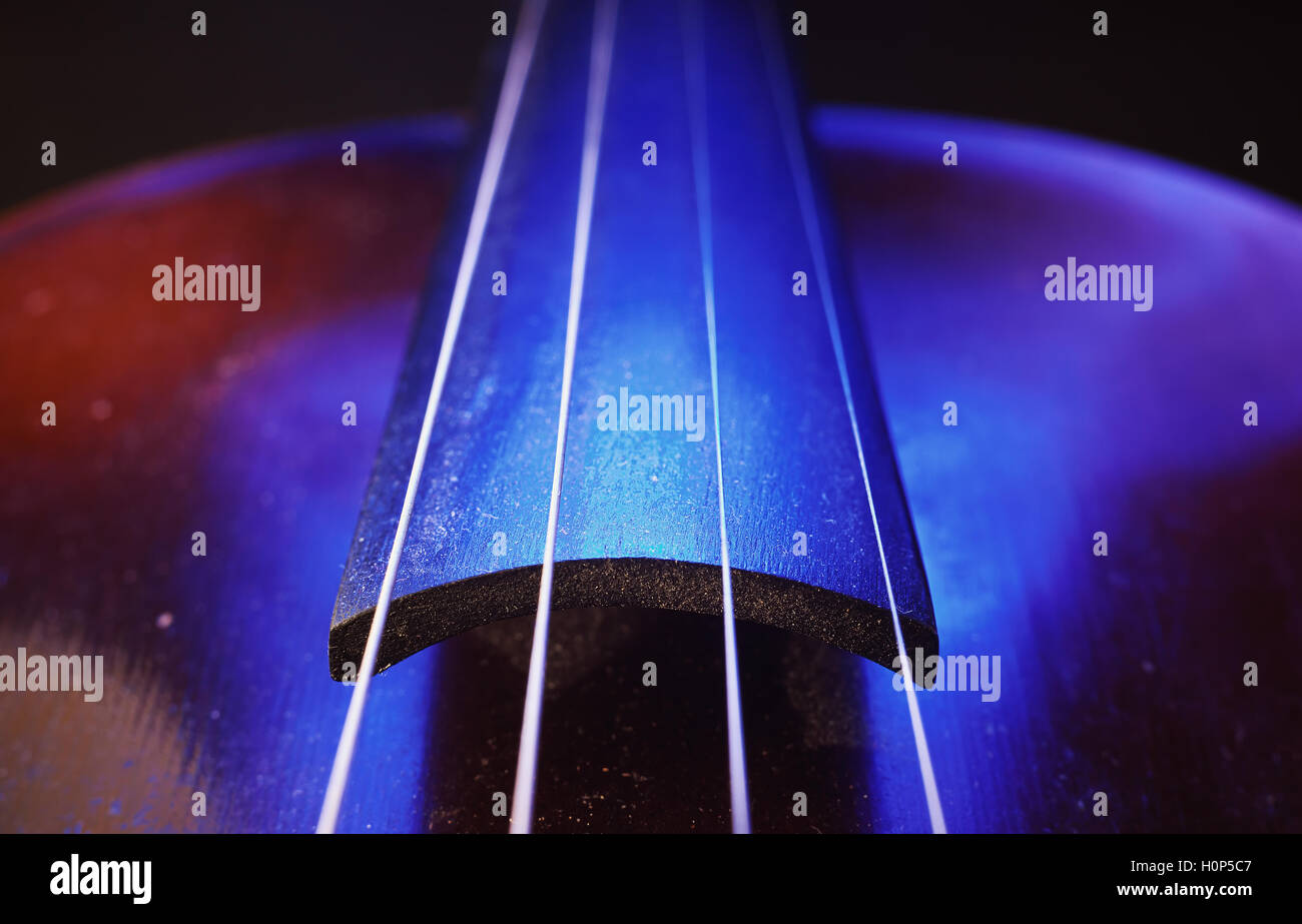 Studio de la composition d'un vieux violon poussiéreux, bleu et violet à partir de l'éclairage de côté, vue rapprochée sur le cou et des chaînes. Banque D'Images