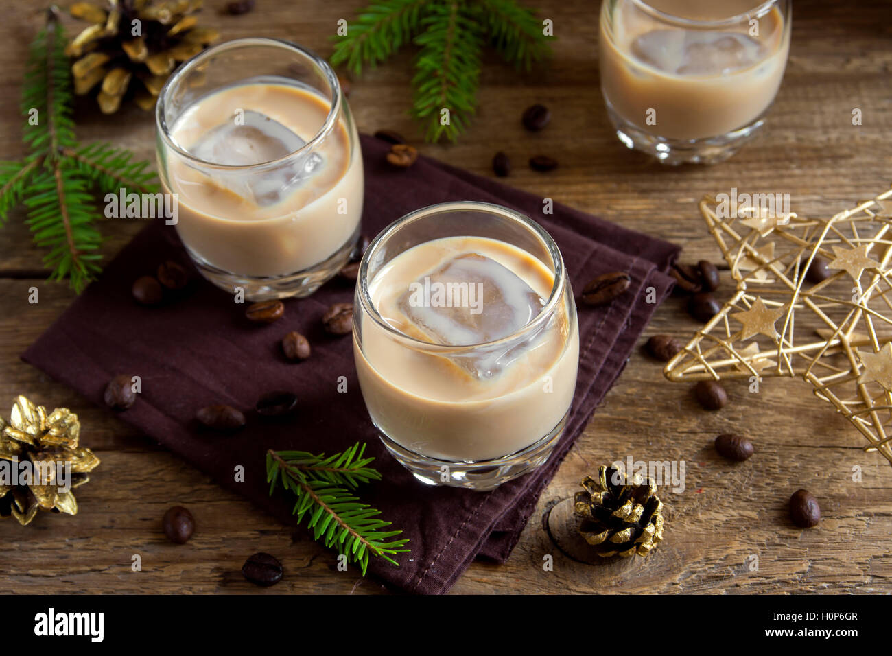 Irish Cream Liqueur de café avec de la glace, et des ornements de décoration de Noël sur fond de bois rustique - boisson festive fait maison Banque D'Images