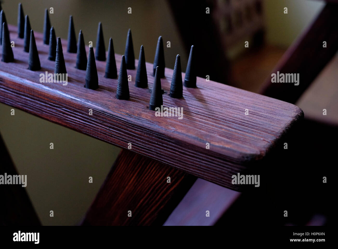 Détail d’une chaise de torture médiévale qui a percé le corps d’une personne à chaque point de contact, allant suffisamment profondément pour briser la peau, mais pas assez loin pour endommager les organes vitaux ou les artères principales. Banque D'Images