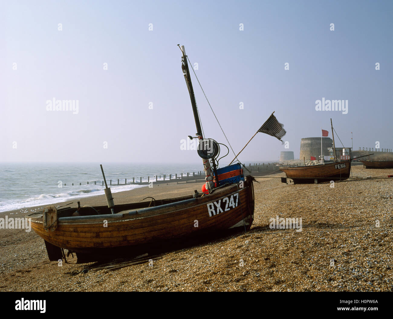 À clins en bois traditionnels bateaux de pêche et les tours Martello géorgienne sur la plage des pêcheurs, Hythe, dans le Kent, en Angleterre. 1992. Banque D'Images