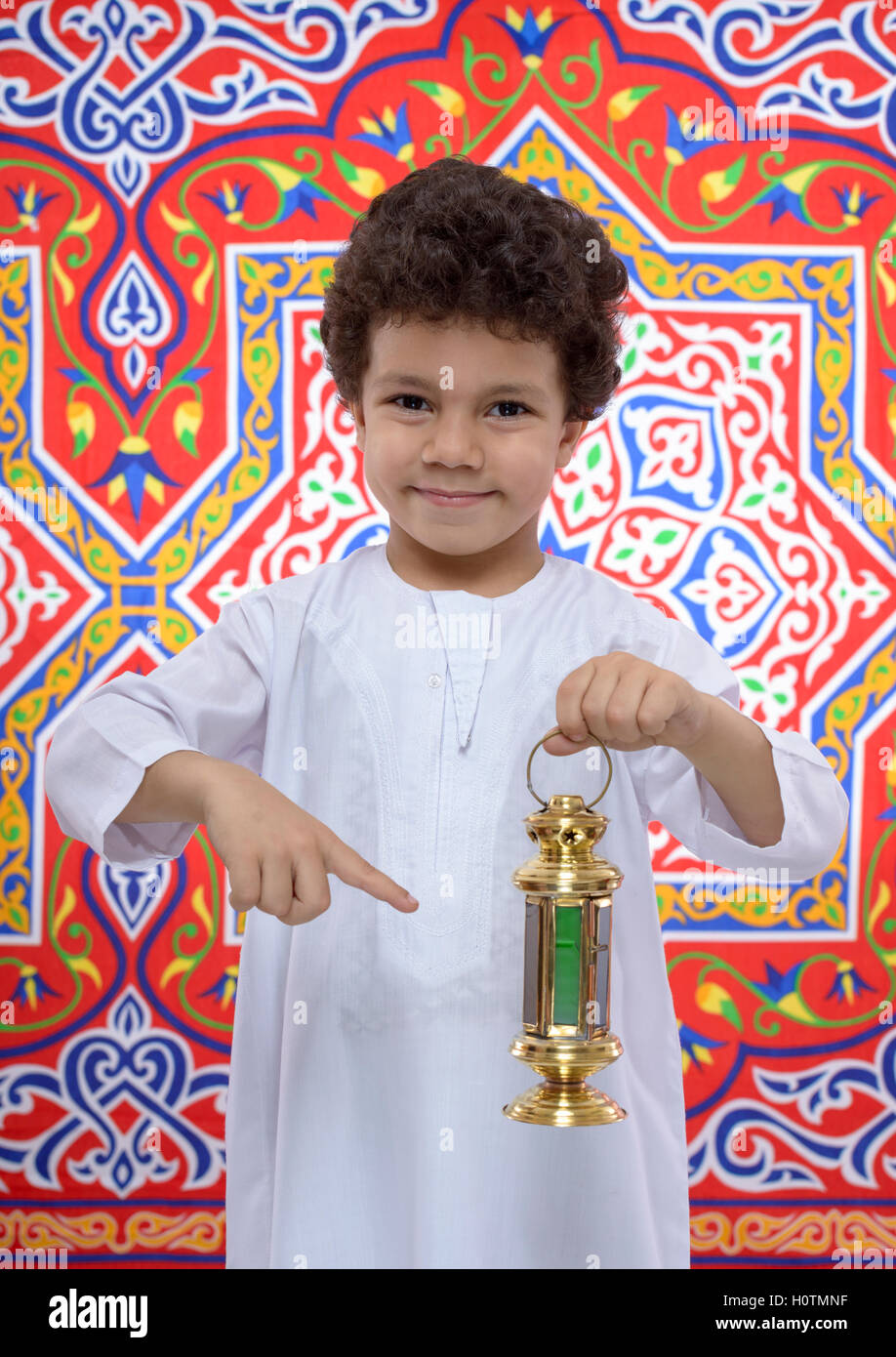 Happy Young Boy Pointing at Ramadan Lantern sur tissu Ramadan Banque D'Images