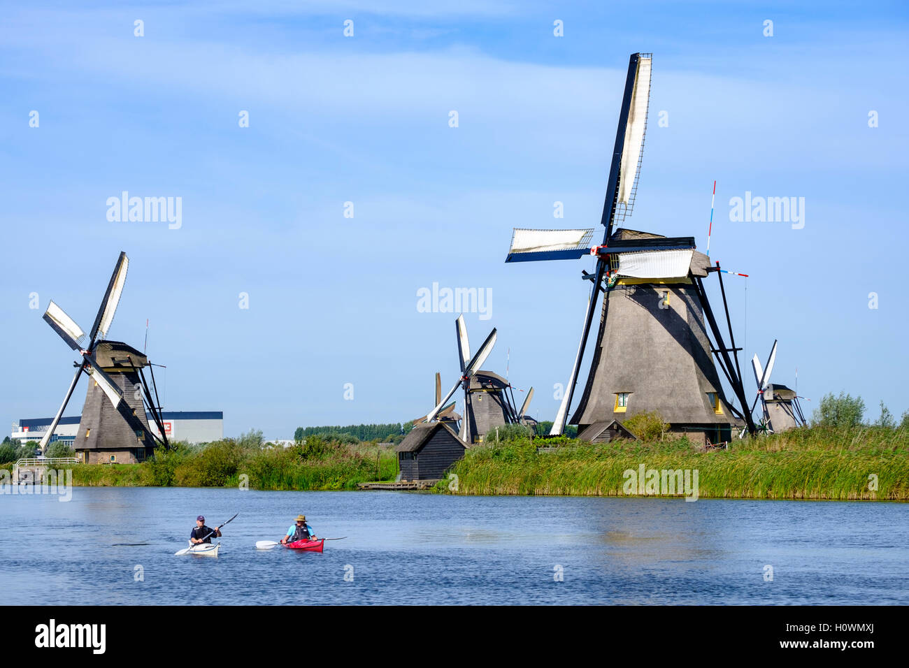 Deux hommes en kayaks en canal au pied du quartier historique de moulins à Kinderdijk Site du patrimoine mondial de l'Unesco aux Pays Bas Banque D'Images