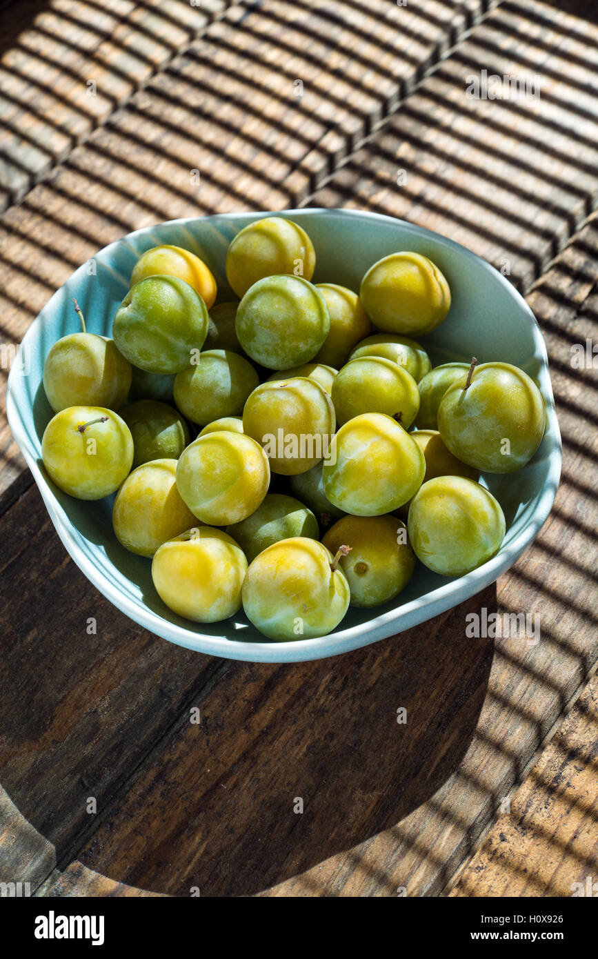 Bol de prunes sur une table en bois Banque D'Images