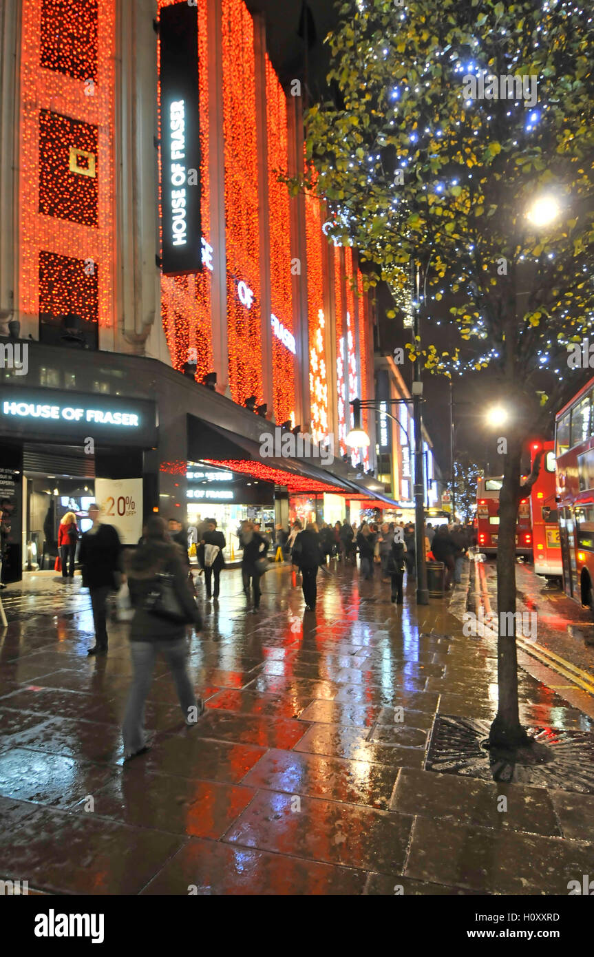 House of Fraser department store avec les consommateurs au Royaume-Uni Oxford street avec des lumières de Noël Réflexions soir de pluie pour le shopping à Londres West End Banque D'Images