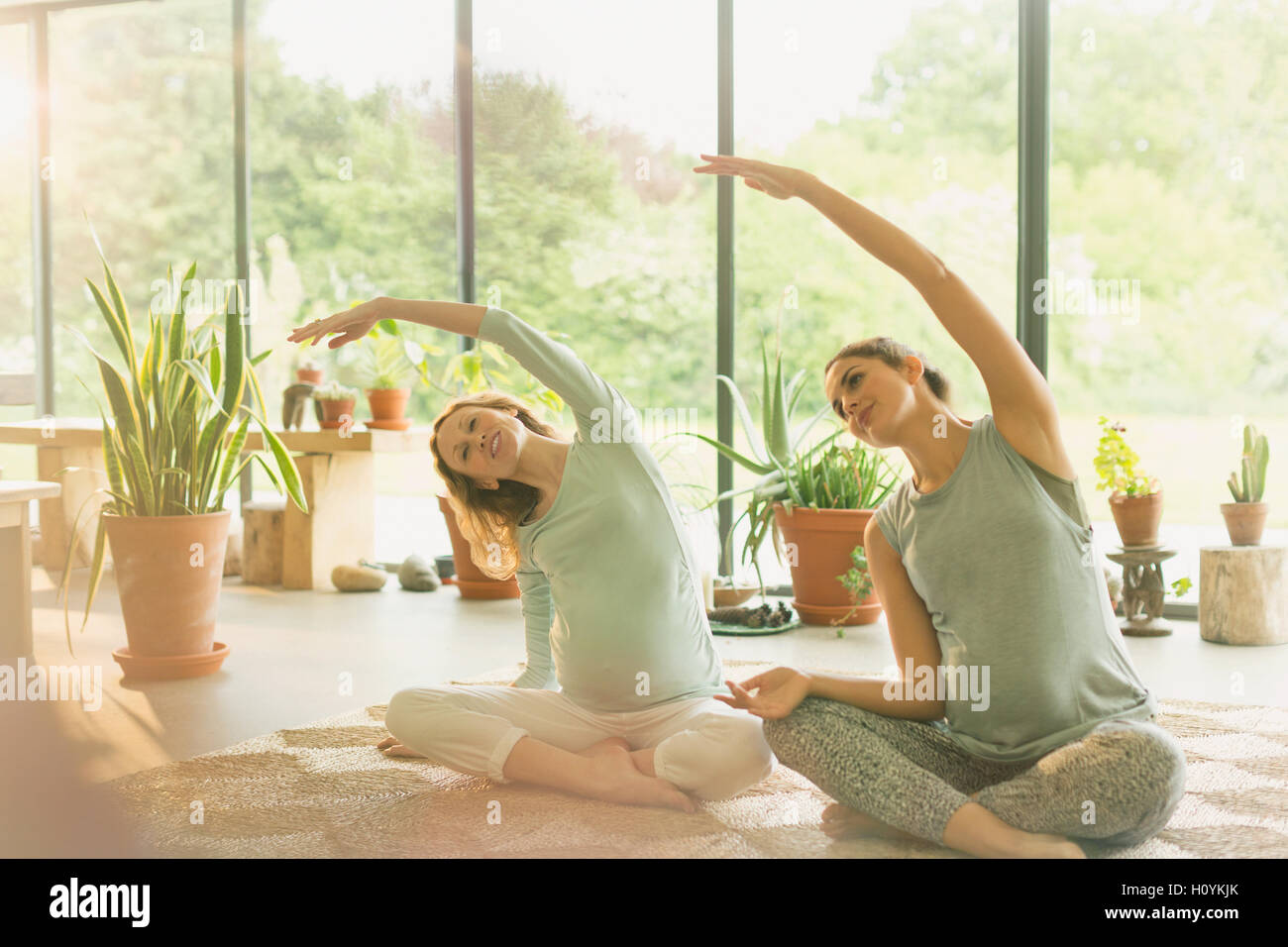 La grossesse woman practicing yoga étirement latéral Banque D'Images
