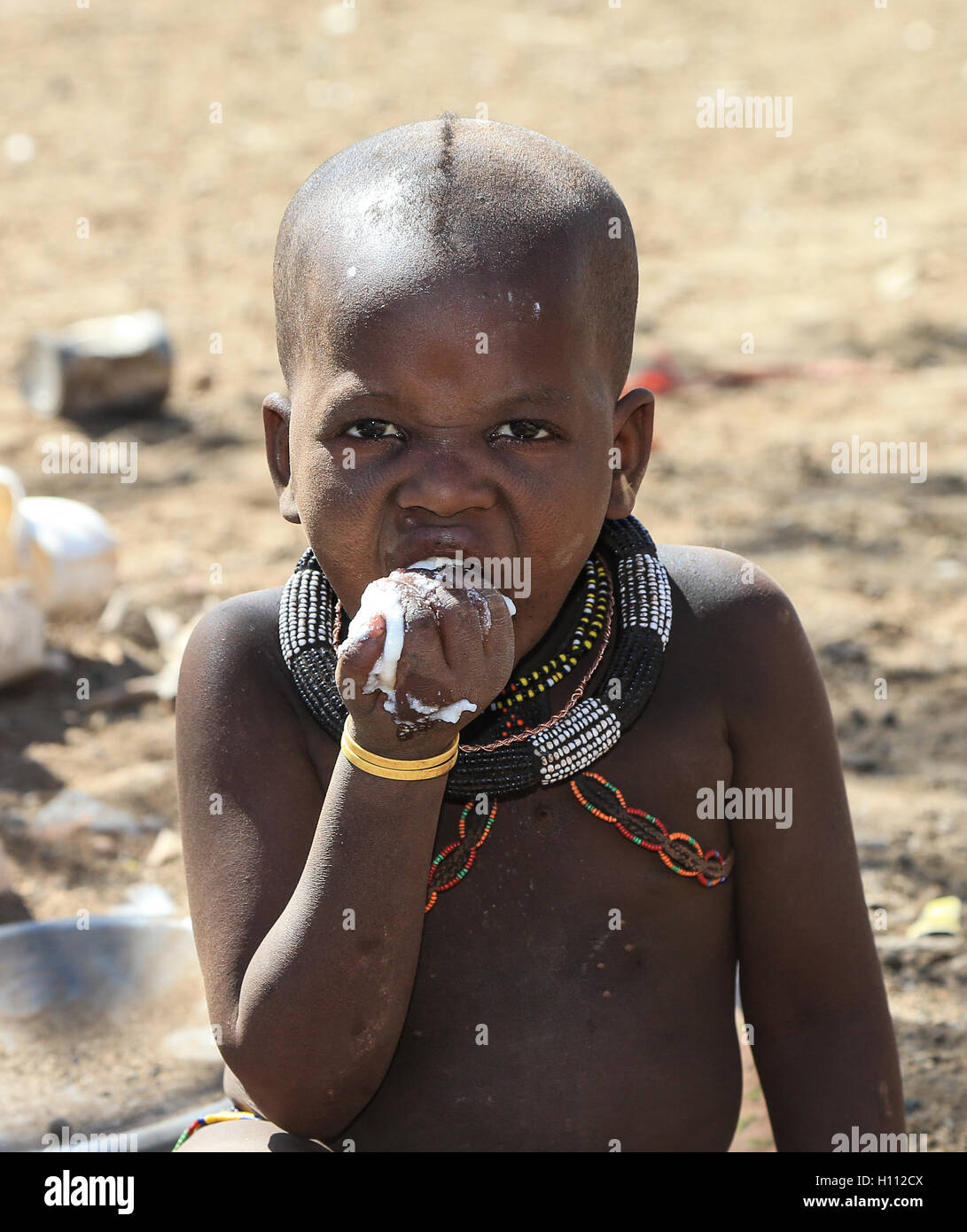 Enfant Himba a un repas à base de maïs dans la région de Kunene Namibie Banque D'Images