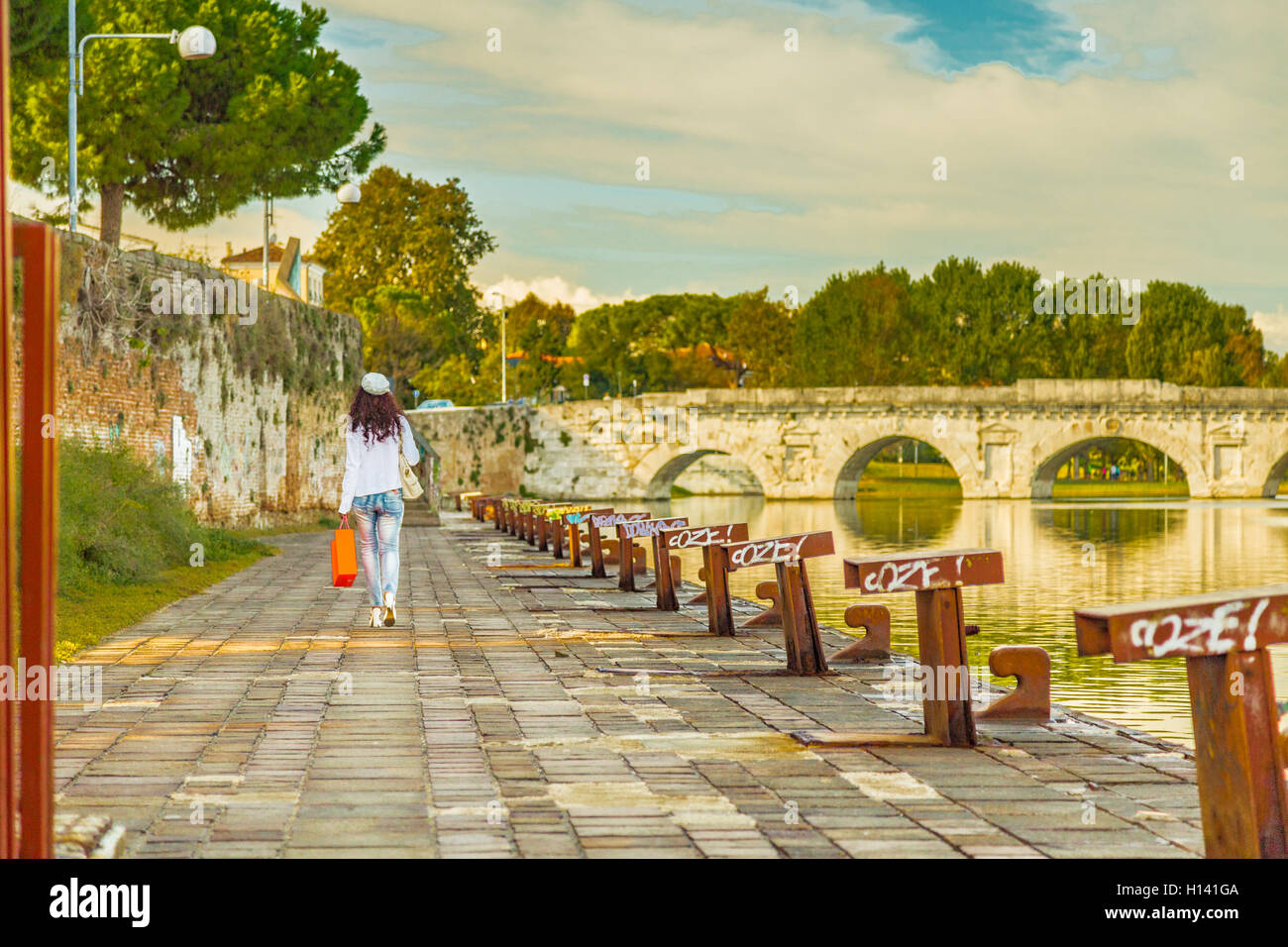 Rimini, Italie, femme marche sur le quai du canal de port près de l'ancien pont romain Banque D'Images