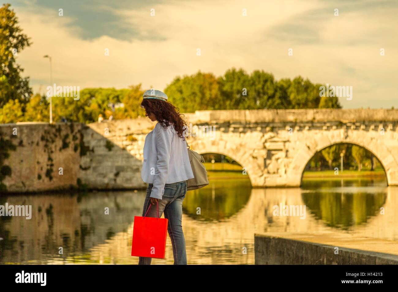 Rimini, Italie, femme marche sur le quai du canal de port près de l'ancien pont romain Banque D'Images