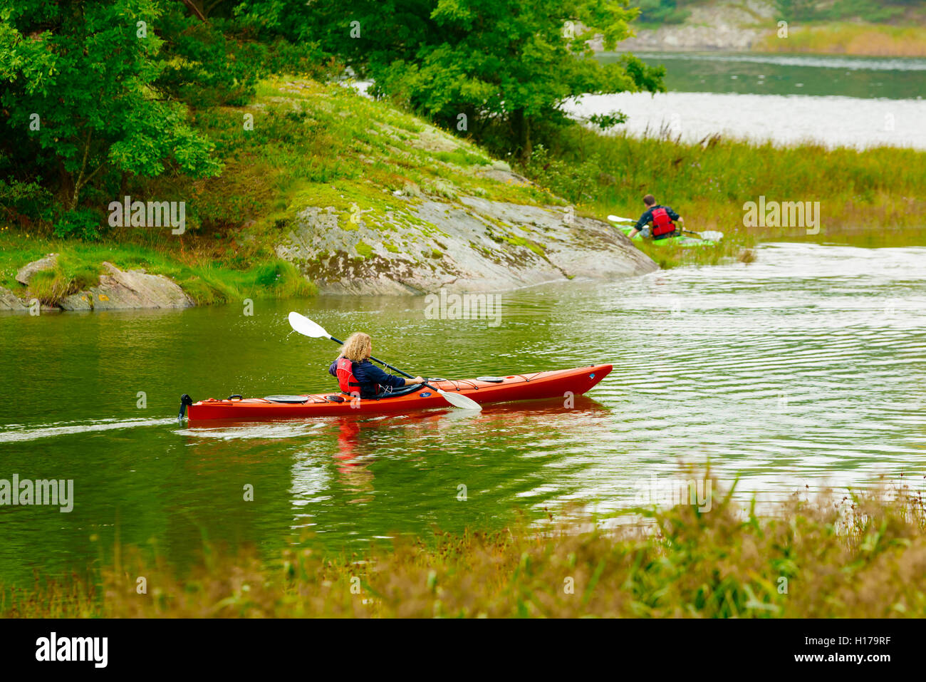 Sundsby, Suède - septembre 9, 2016 : documentaire Voyage de femme kayak sur les eaux tranquilles d'un boisé légèrement jour brumeux dans Banque D'Images
