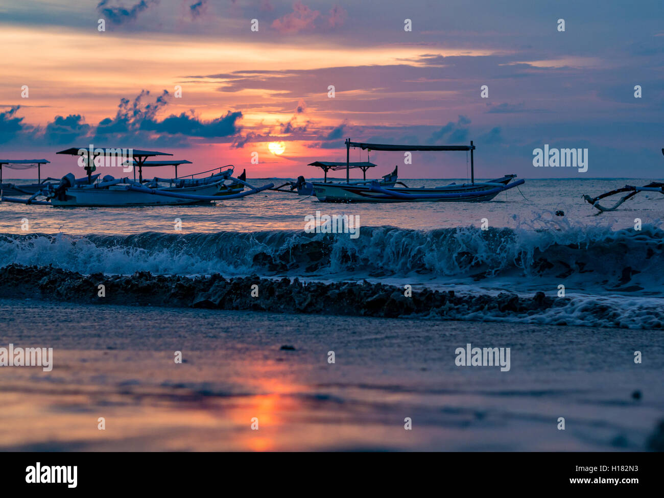 Navires Jukung balinais traditionnels à proximité sur la plage de Sanur, au lever du soleil, Bali, Indonésie Banque D'Images