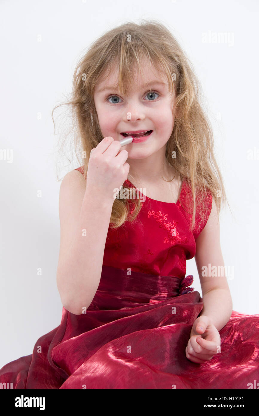 Jouer avec make-up : 6 ans, fille, portant robe de soirée rouge brillant  séance pratique de l'application de rouge à lèvres Photo Stock - Alamy