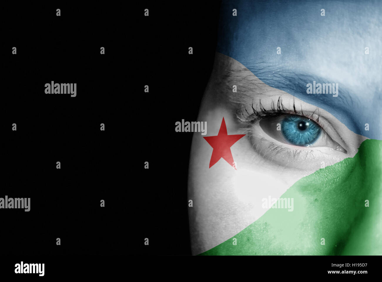 Une jeune femme avec le drapeau de Djibouti peint sur son visage sur son chemin à un événement sportif pour montrer son soutien. Banque D'Images