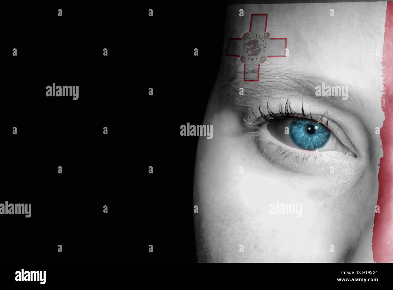 Une jeune femme avec le drapeau de Malte peint sur son visage sur son chemin à un événement sportif pour montrer son soutien. Banque D'Images