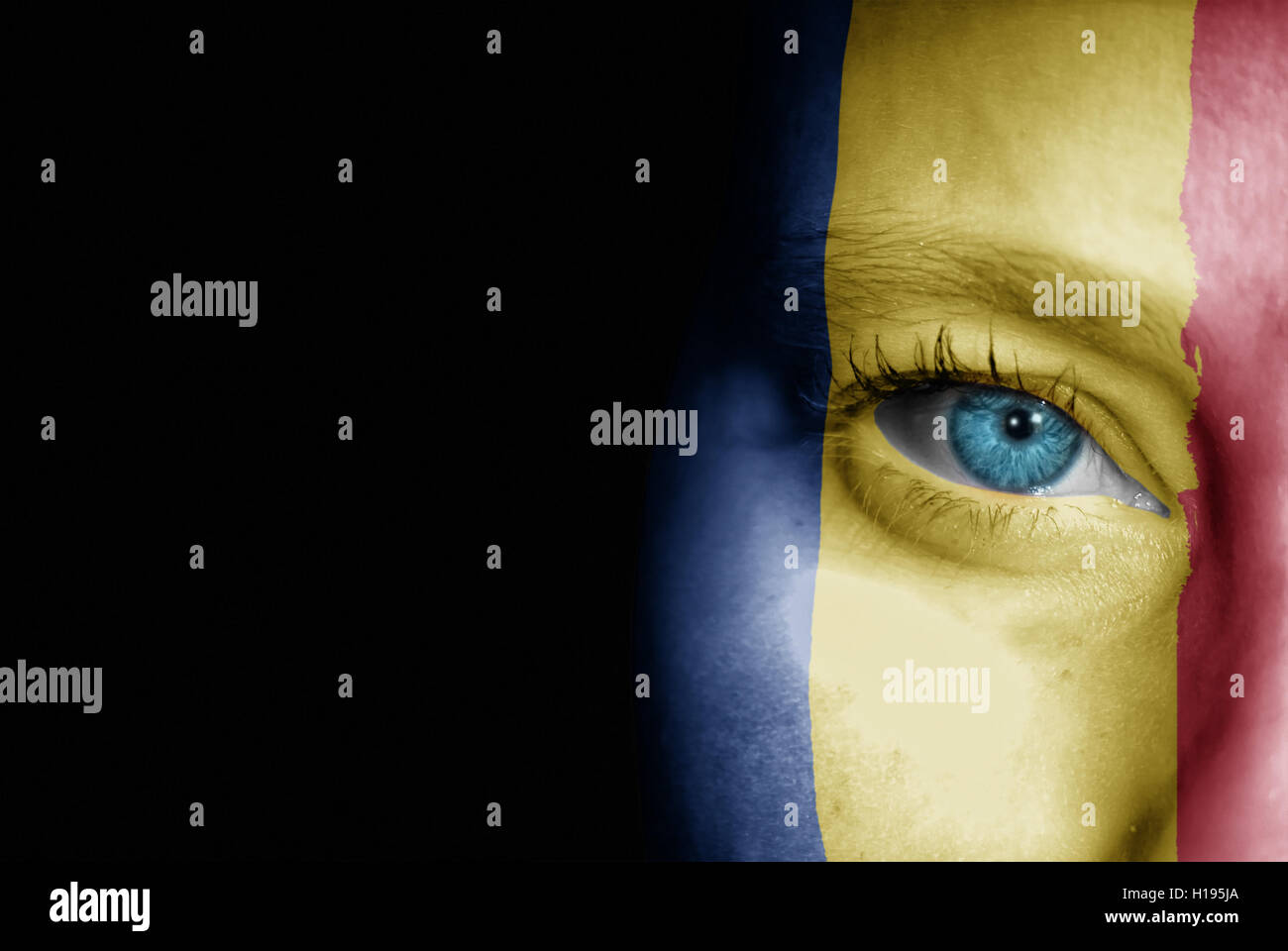 Une jeune femme avec le drapeau de la Roumanie peint sur son visage sur son chemin à un événement sportif pour montrer son soutien. Banque D'Images