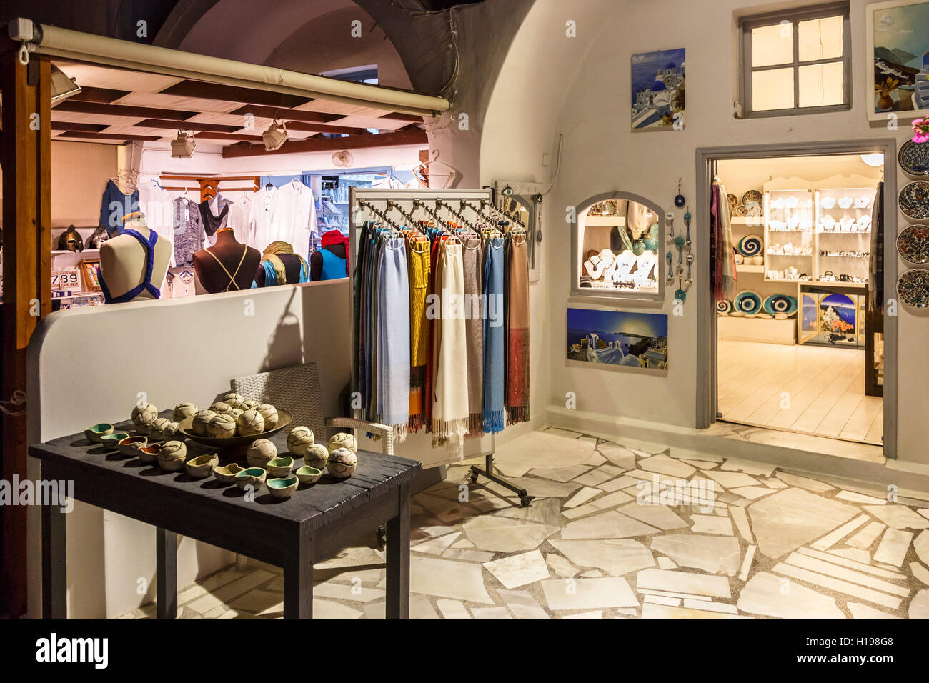 Les tissus et de souvenirs sur l'écran dans un magasin à Oia, Santorin, une île grecque de la Méditerranée dans le groupe des Cyclades Banque D'Images