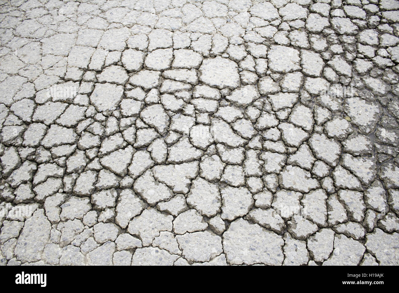 Sol gris fissuré dans la construction de routes en milieu urbain Banque D'Images