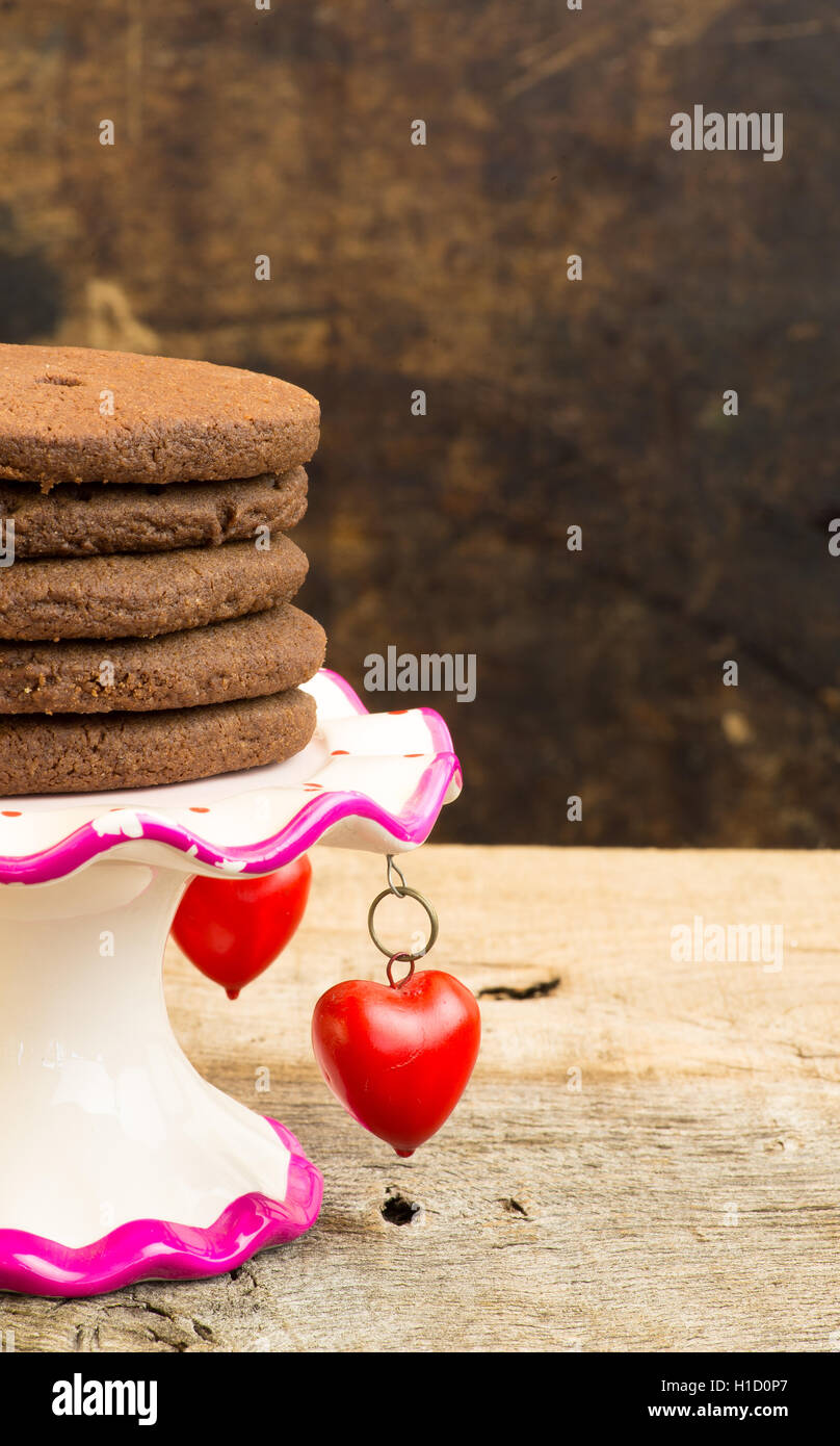 Chocolat chaud mexicain heart shaped shortbread cookies avec le poivre de cayenne et la cannelle sur un stand avec des pendentifs coeur rouge Banque D'Images