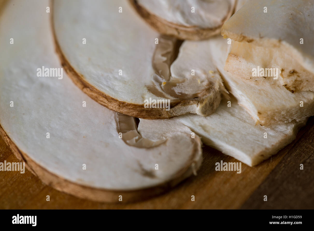 Crimini (Baby Bella) champignons, tranchés et placés dans des couches sur planche à découper en bois rayé. Pris comme un gros plan avec un objectif macro Banque D'Images