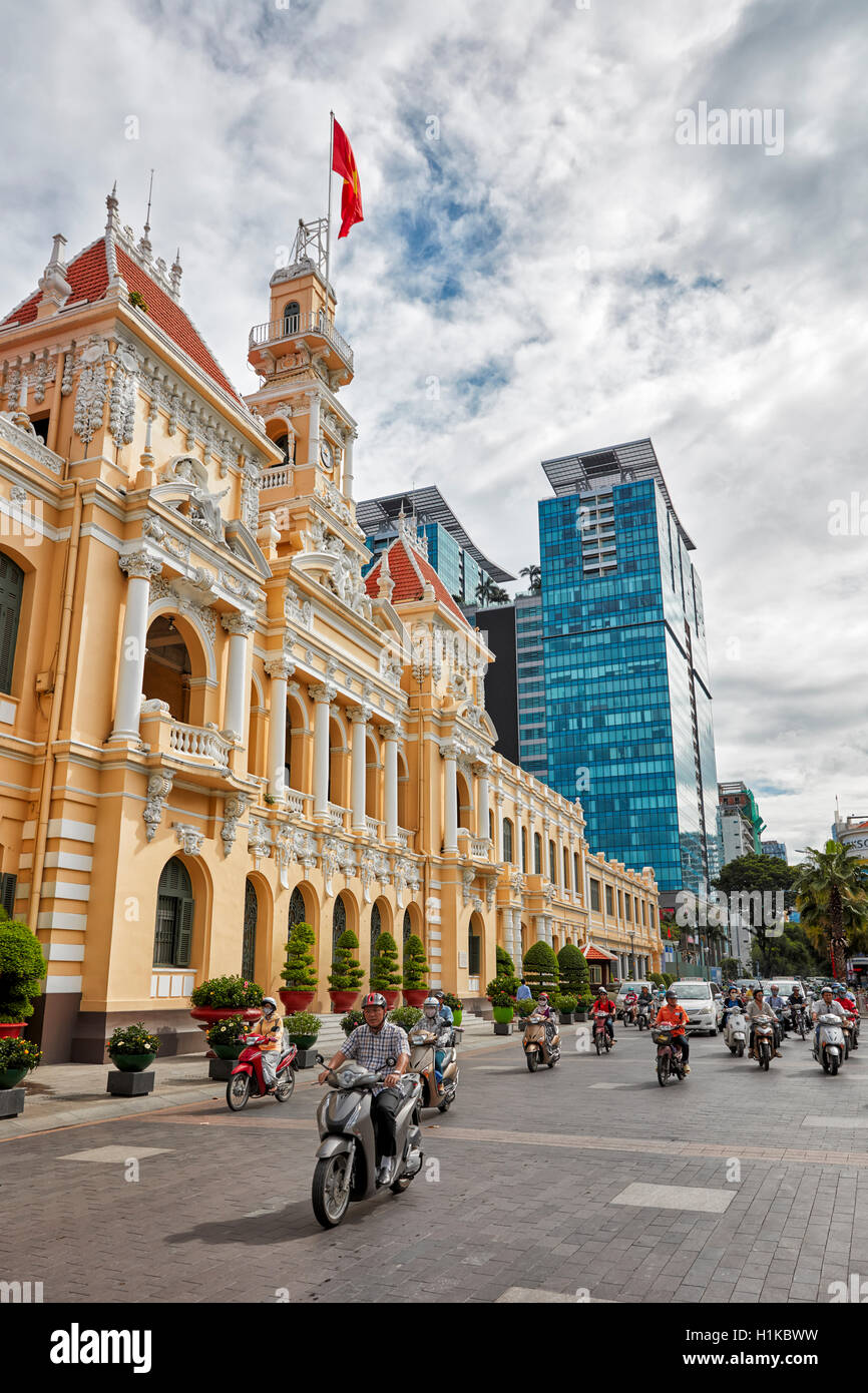 La population locale sur les motos en passant par la construction du Comité populaire. Le Thanh Ton street, Ho Chi Minh City, Vietnam. Banque D'Images