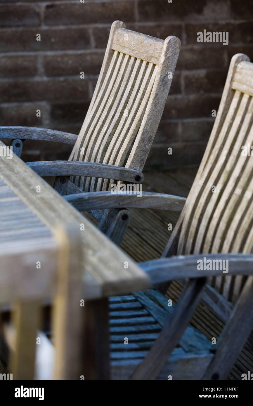 Les vieux meubles en bois dans un jardin entouré d'une brique en wll la lumière du matin. Banque D'Images