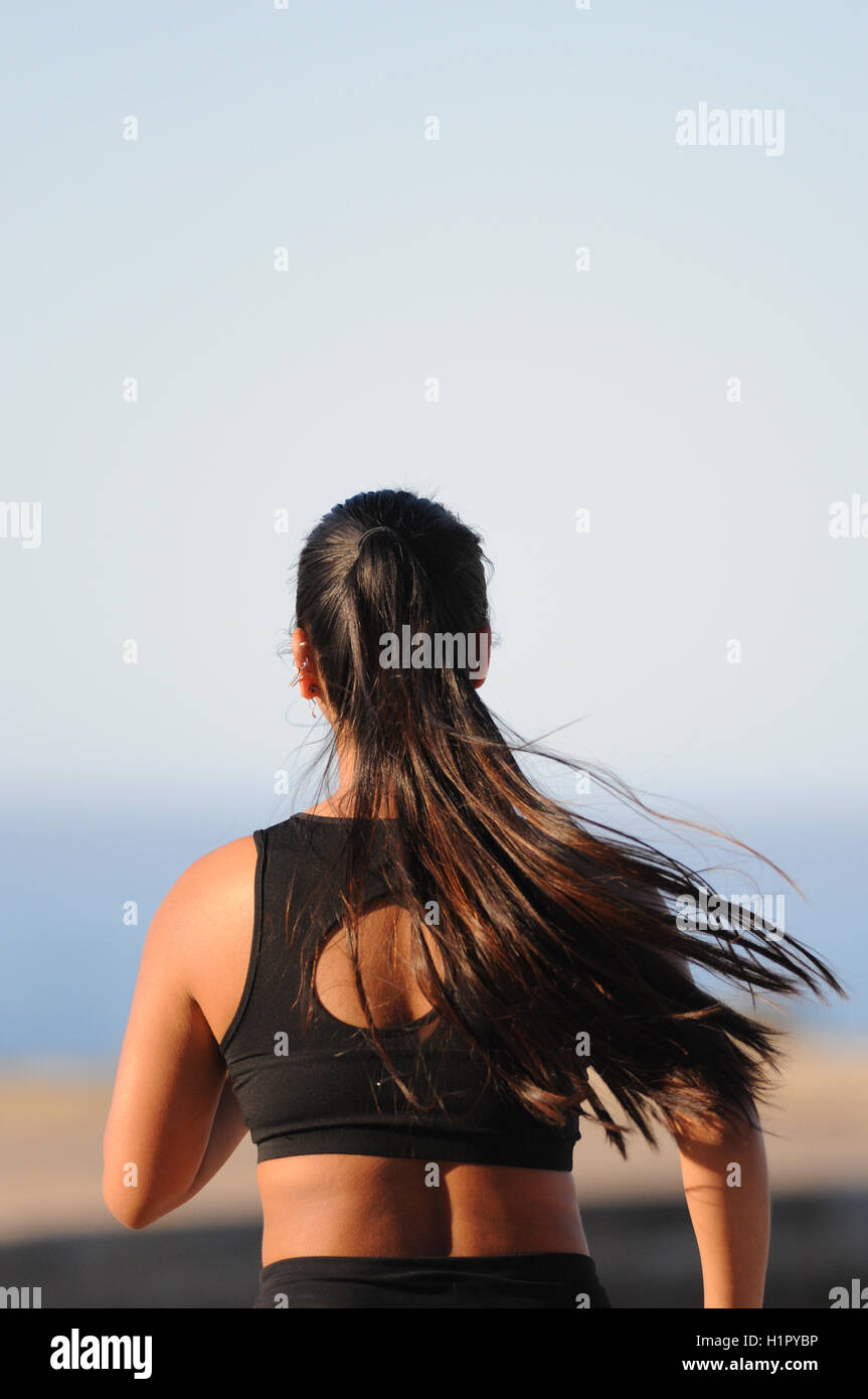 Jogging fille courir à l'extérieur dans le soleil d'avertir Banque D'Images