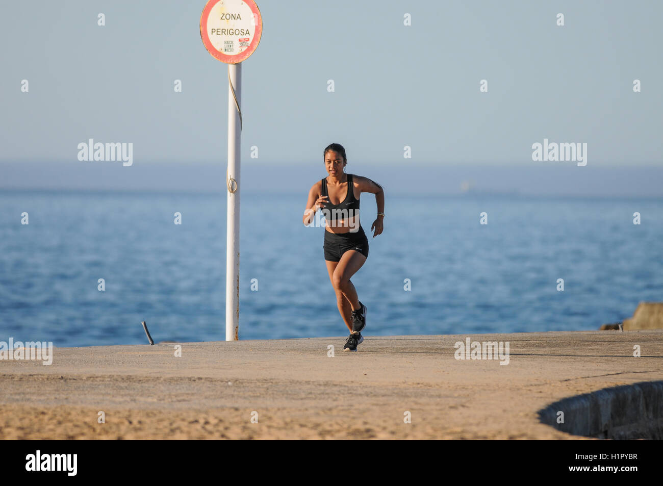 Jogging fille courir à l'extérieur dans le soleil d'avertir Banque D'Images