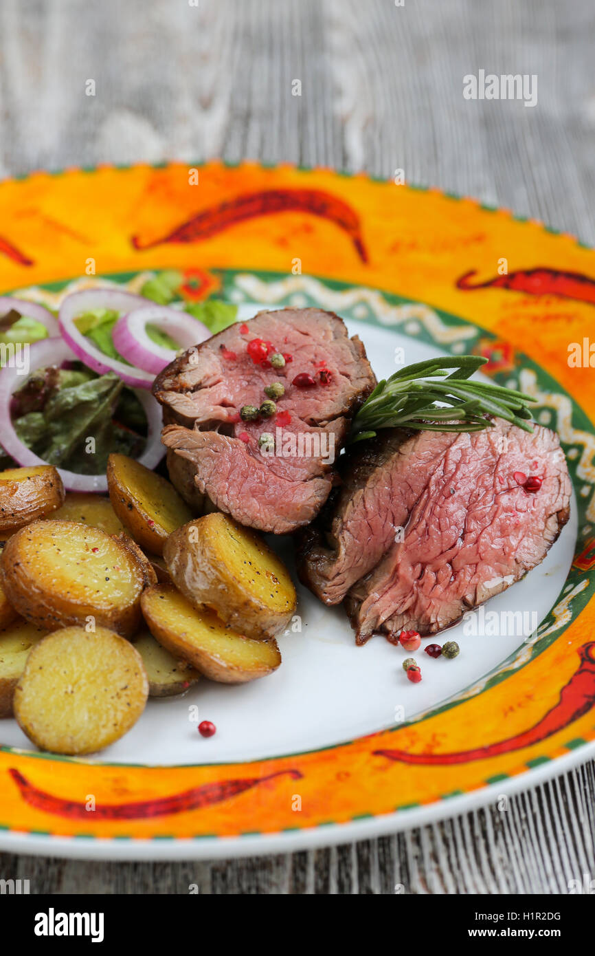 Pavé de boeuf avec pommes de terre au four Banque D'Images