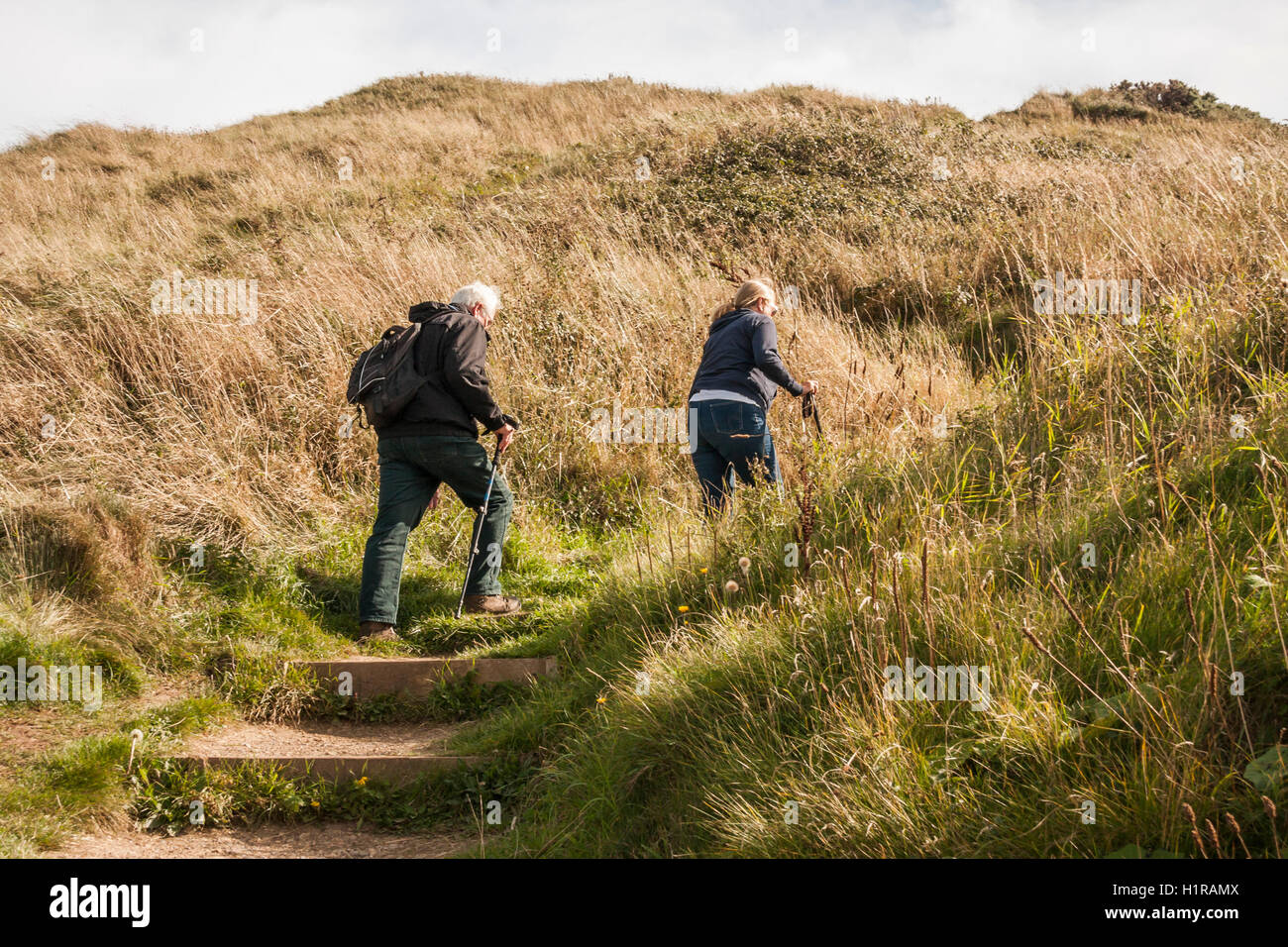 Mâles et femelles matures les randonneurs l'ascension de la pente raide sur le Cleveland Way à Saltburn by the Sea Banque D'Images