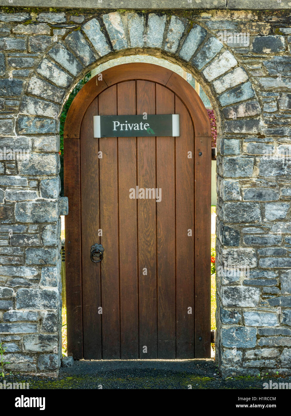 L'architecture intéressante mur de pierre représentant une porte en bois marqué privé. Abbaye de Buckfast, Monastère, Dartmoor National Park Banque D'Images