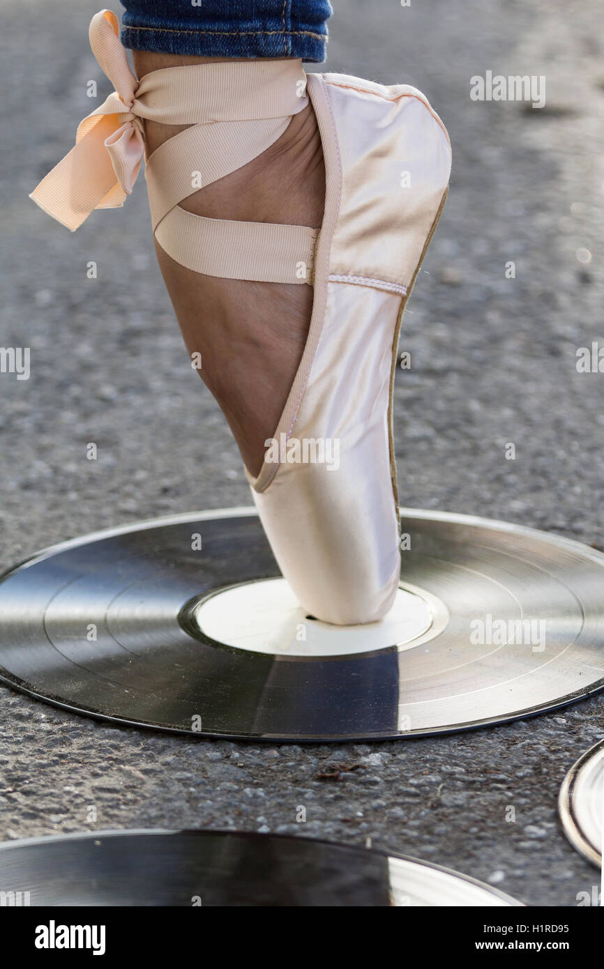 Filles de pied dans Ballet Shoes se dresse sur un disque vinyle Banque D'Images