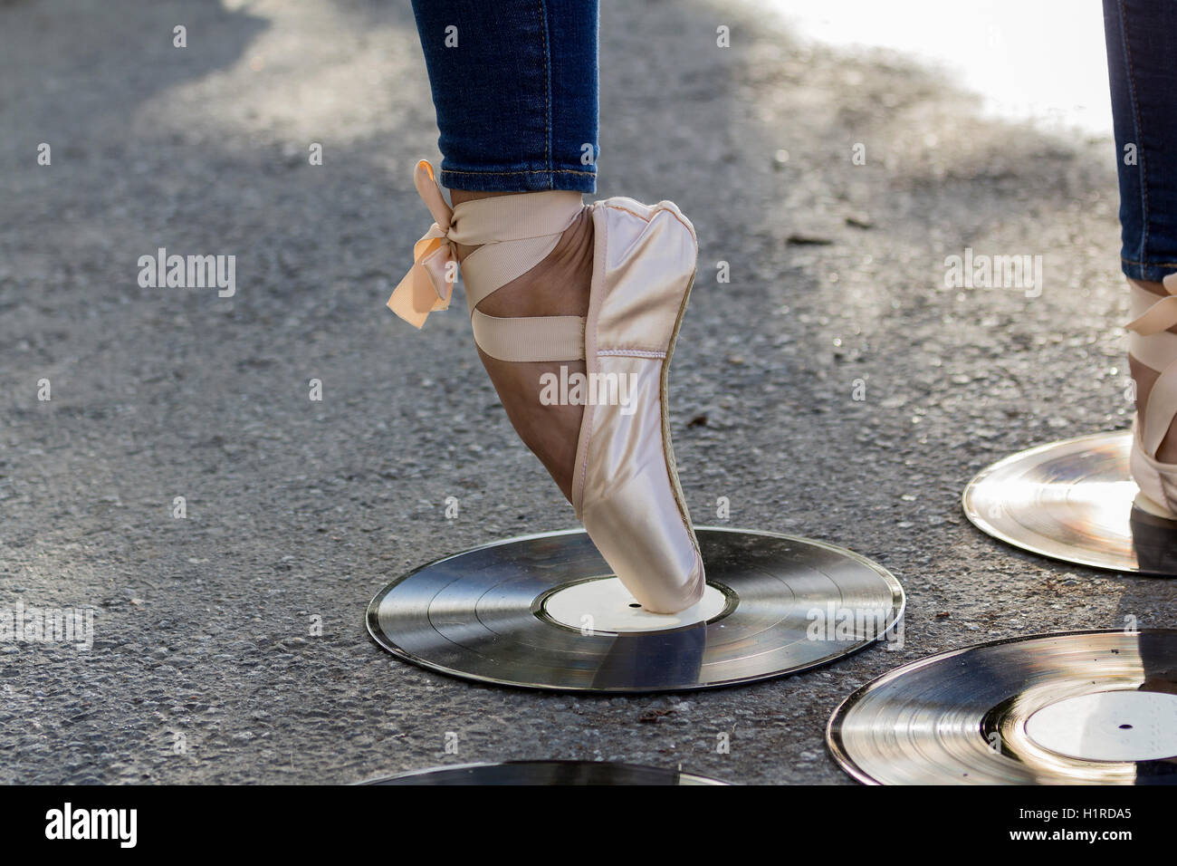 Pieds fille dans Ballet Shoes stand au milieu de disques vinyle. Banque D'Images