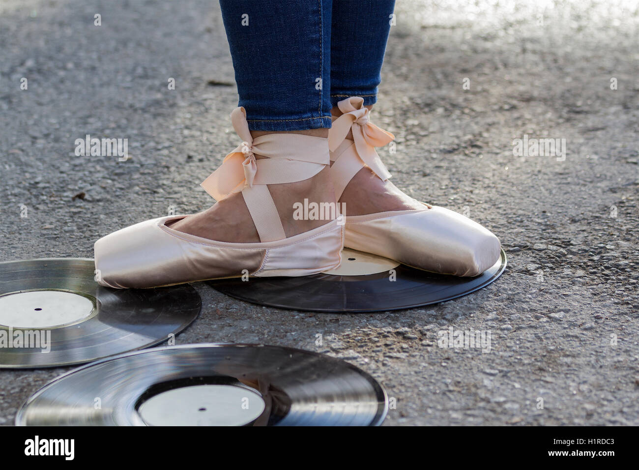 Pieds fille dans Ballet Shoes stand au milieu de disques vinyle. Banque D'Images