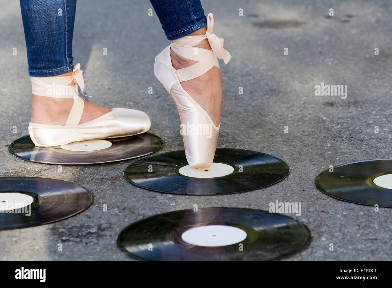 Filles de pied dans Ballet Shoes se dresse sur un disque vinyle. Banque D'Images