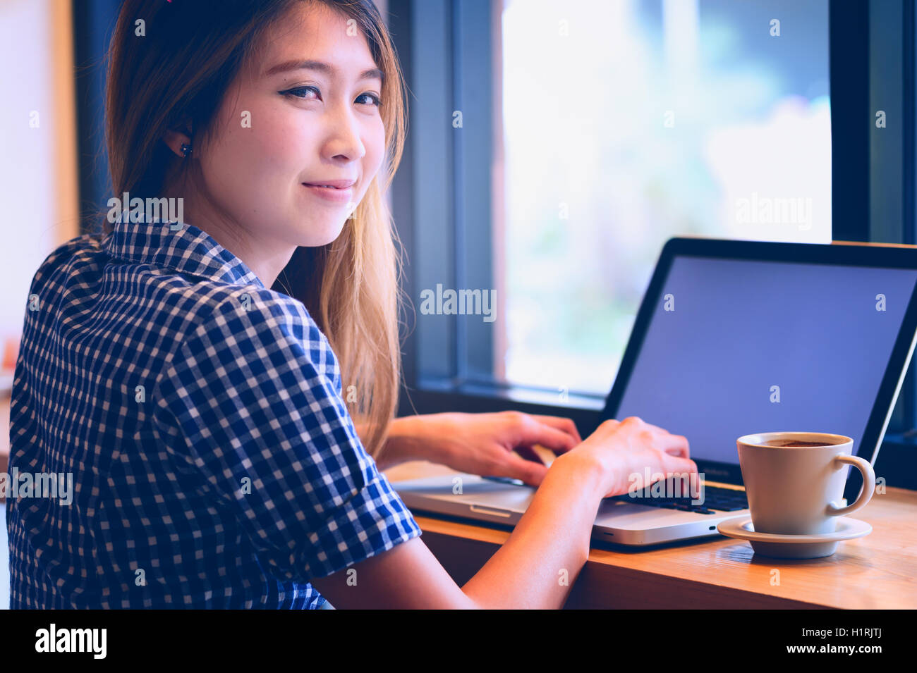 Belle Asie en utilisant son ordinateur portable et de boire tasse de café en café, de vacances concept. Banque D'Images