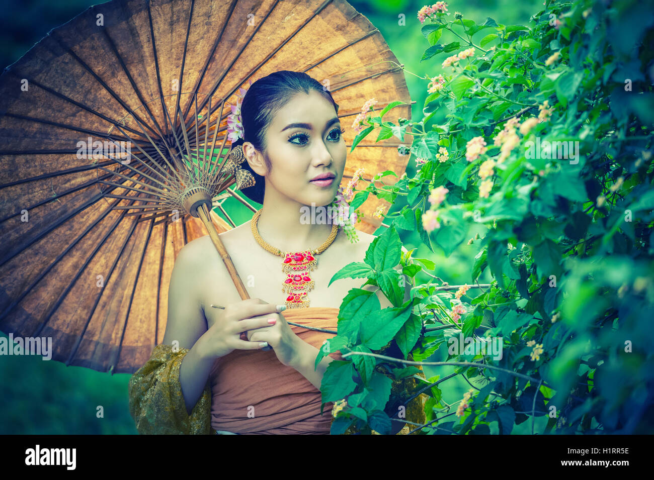 L'ancienne femme thaïlandaise en costume traditionnel de la Thaïlande avec parapluie vintage, effet vintage Banque D'Images