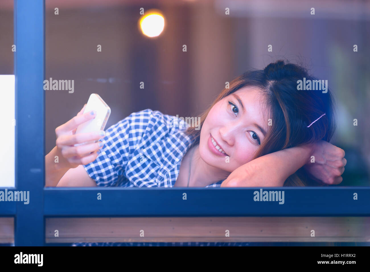 Asie sourire femme assis à table de bar et des textos avec son mobile , Vacations concept. Banque D'Images