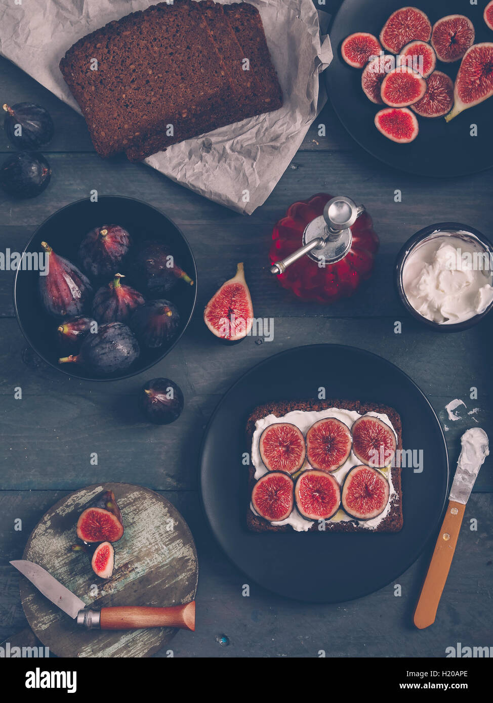 Pain de seigle grillé au fromage à la crème, tranches de figues et d'huile d'olive sur en bois Banque D'Images