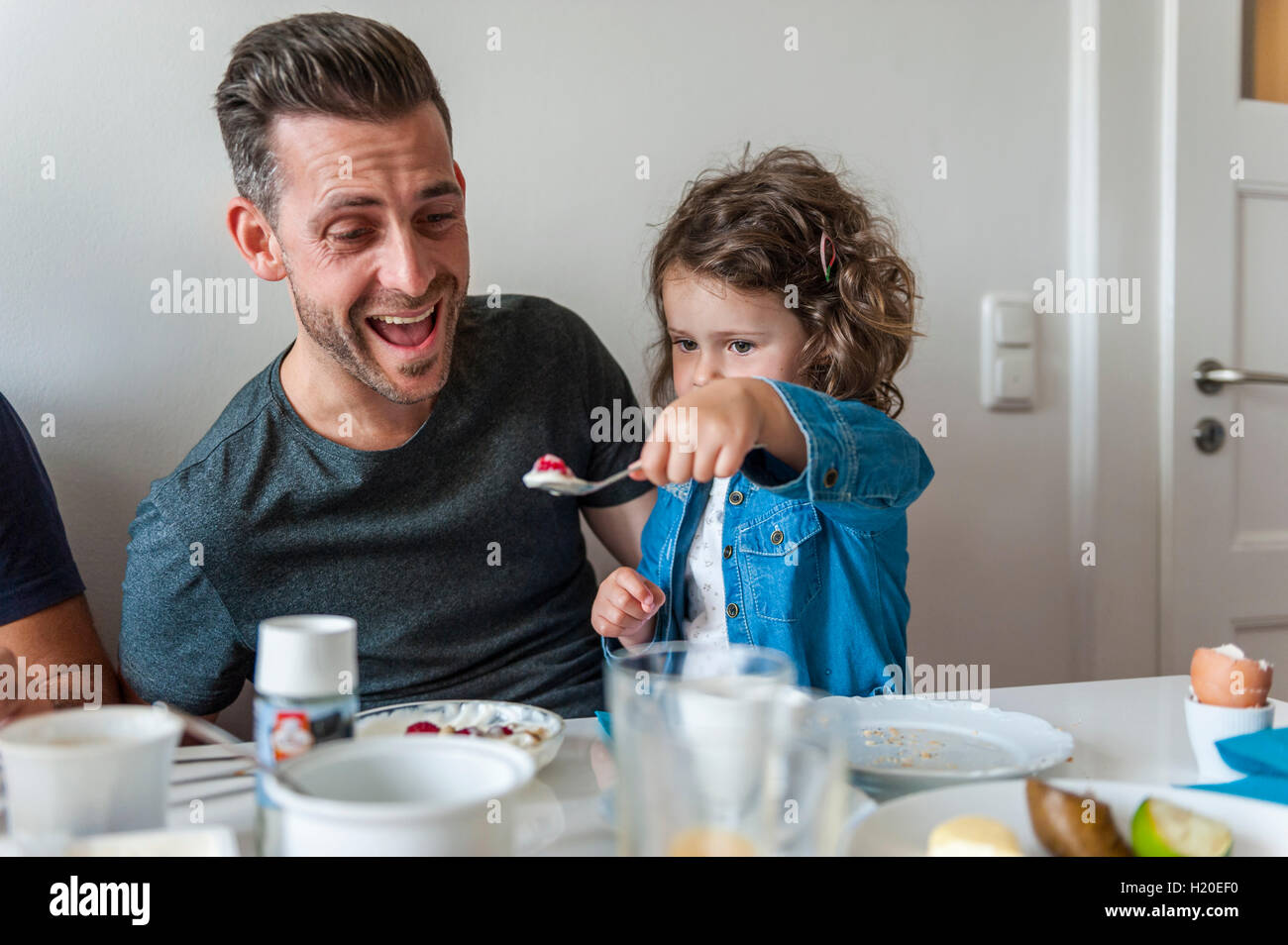 Père et fille prenant le petit déjeuner avec eux Banque D'Images