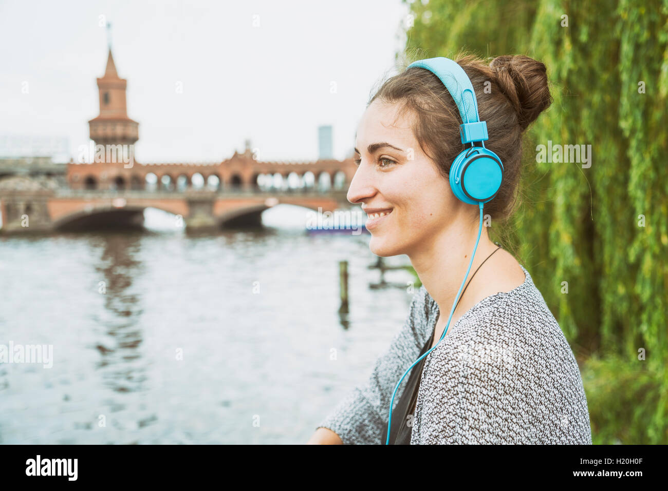Allemagne, Berlin, relaxed woman listening music with headphones Banque D'Images