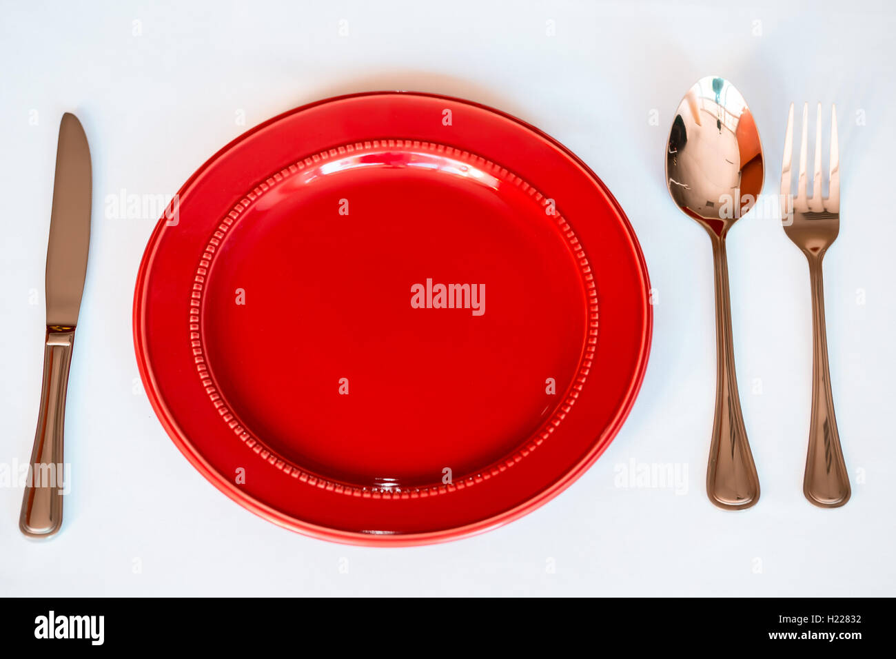 Noël arrière-plan - élégante plaque rouge avec les cookies et la cuillère, fourchette, couteau. Banque D'Images
