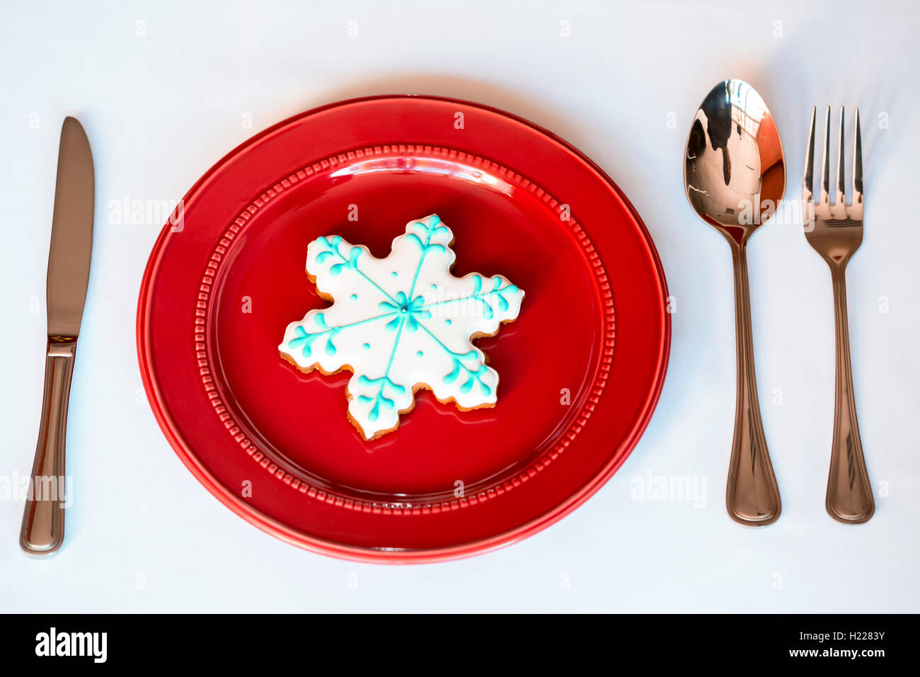 Noël arrière-plan - élégante plaque rouge avec les cookies et la cuillère, fourchette, couteau. Banque D'Images