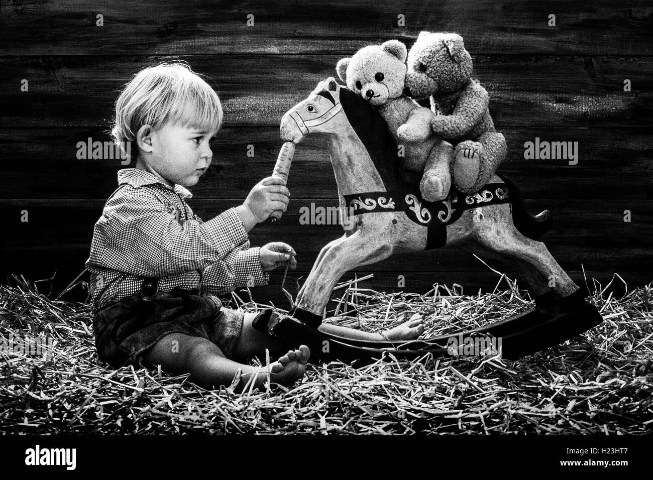 Fillette de trois ans cheval à bascule d'alimentation, teddy bears équitation, Autriche Banque D'Images