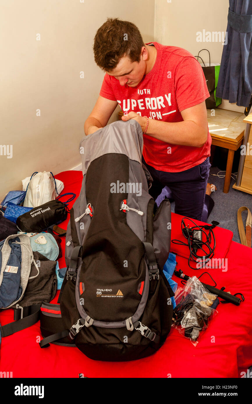 Un jeune homme Packs son sac à dos pour voyager, Sussex, UK Banque D'Images