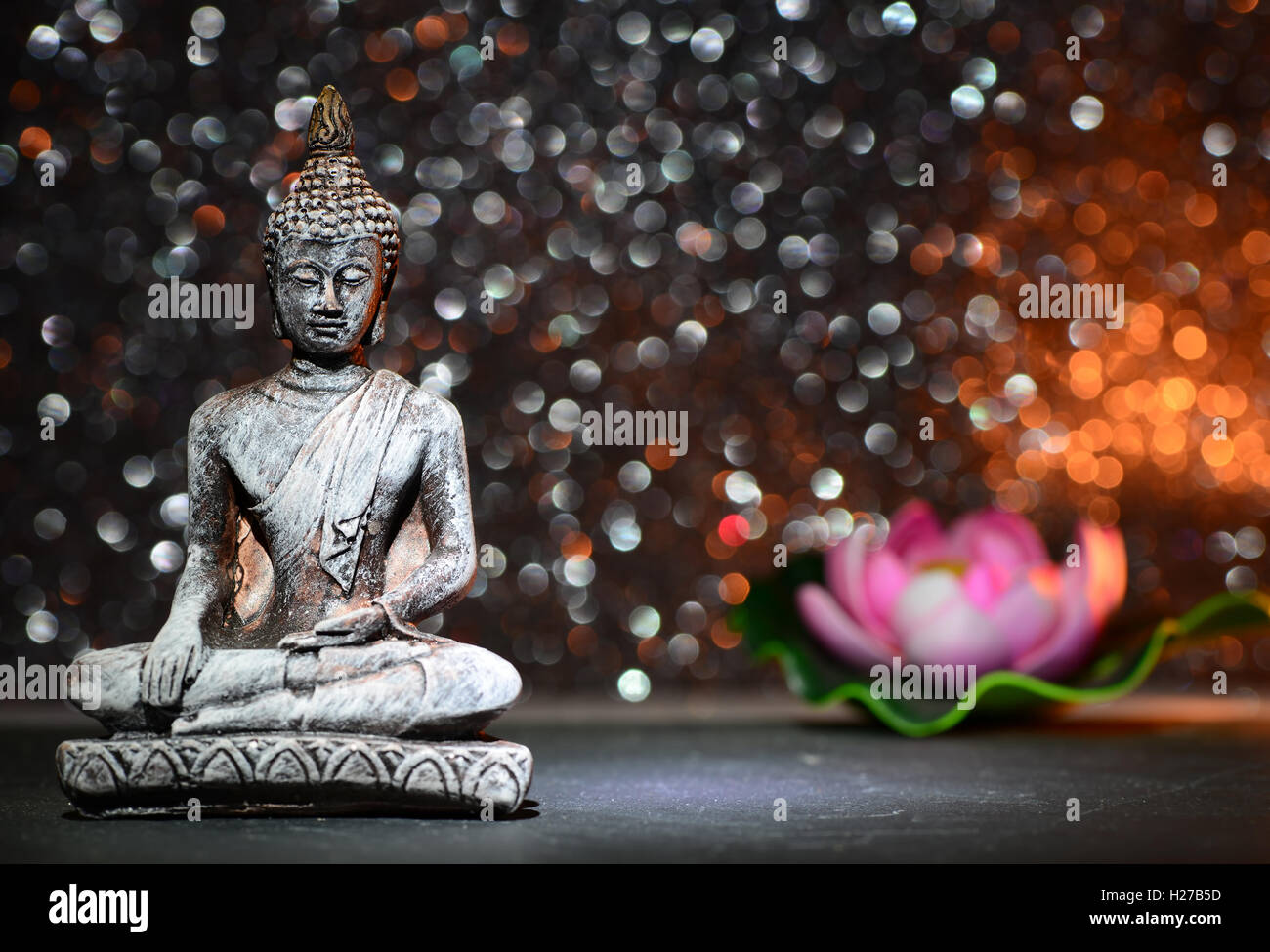 Statue de Bouddha zen sur un brillant lumineux glitter avec bokeh Banque D'Images