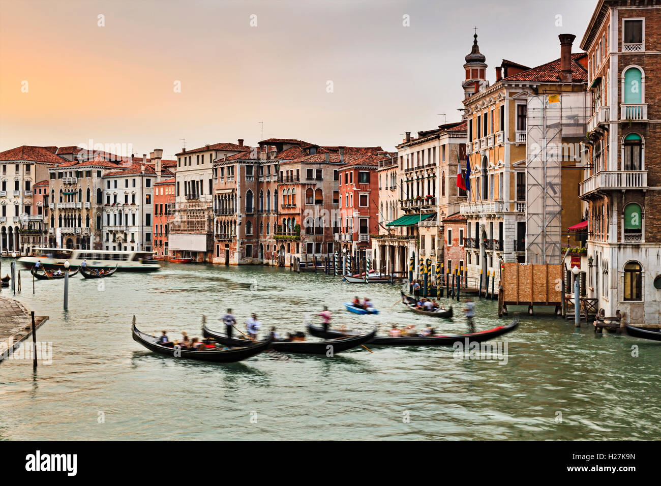3 cabine dans le milieu du Grand Canal à Venise au coucher du soleil contre le palais et maisons colorées à côté de ce transport principal Banque D'Images