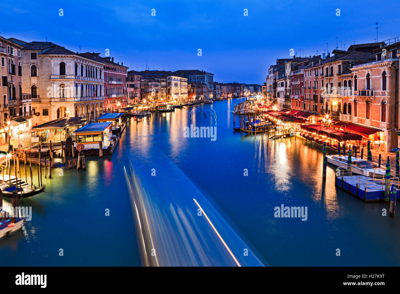 L'eau bleu de Venise Grand Canal du pont du Rialto au coucher du soleil quand à proximité de palais, de cafés et de services sont allumés. Banque D'Images