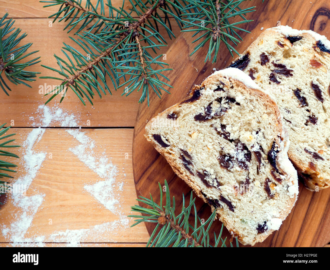 Gâteau de Noël allemand Stollen texturé sur la planche de bois et de branches d'épinette bleue sur les planches en bois avec du sucre t Noël Banque D'Images