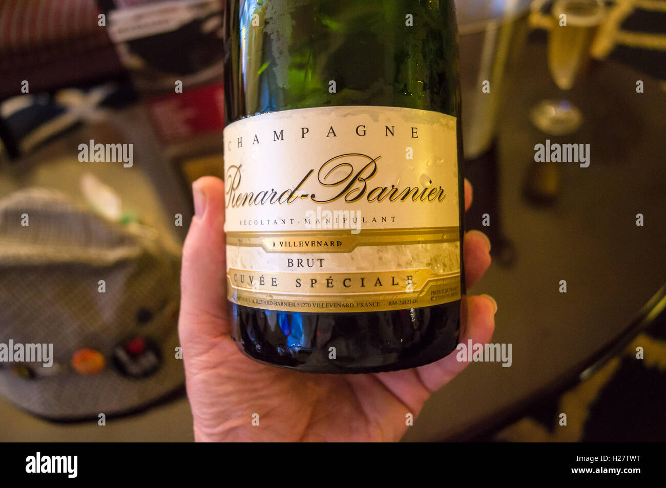 Close-up d'une bouteille de Champagne Renard-Barnier tenue à une main d'homme Banque D'Images