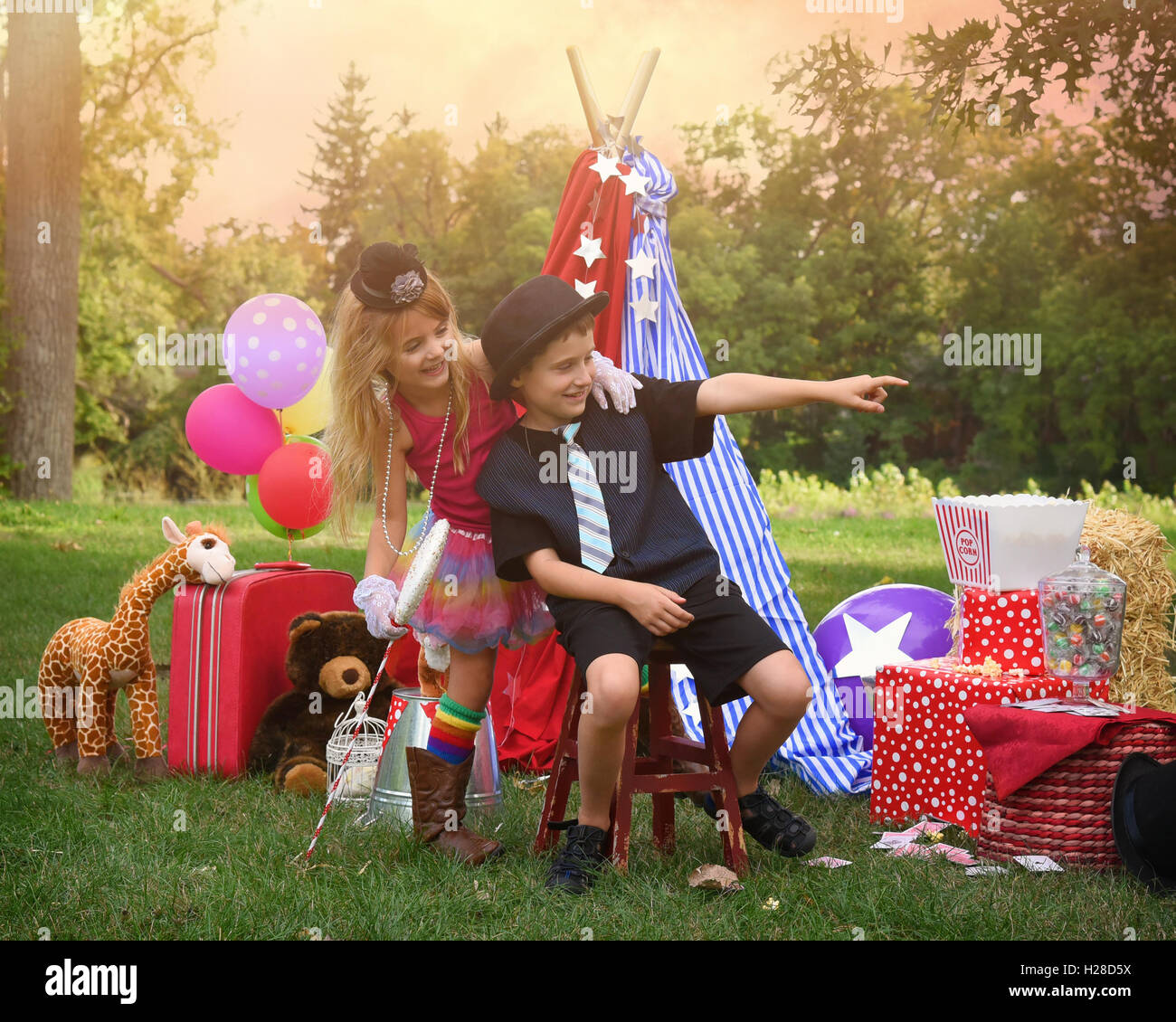 Deux enfants jouent à l'extérieur en s'habillant comme carnival personnes lors d'une partie du cirque pour une imagination ou creativity concept Banque D'Images