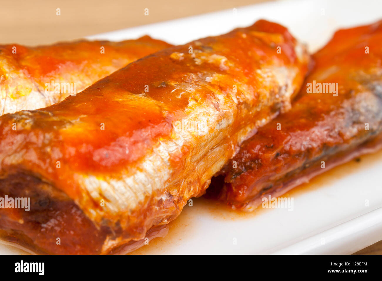 Gros plan de sardines dans une riche sauce tomate sur une plaque Banque D'Images